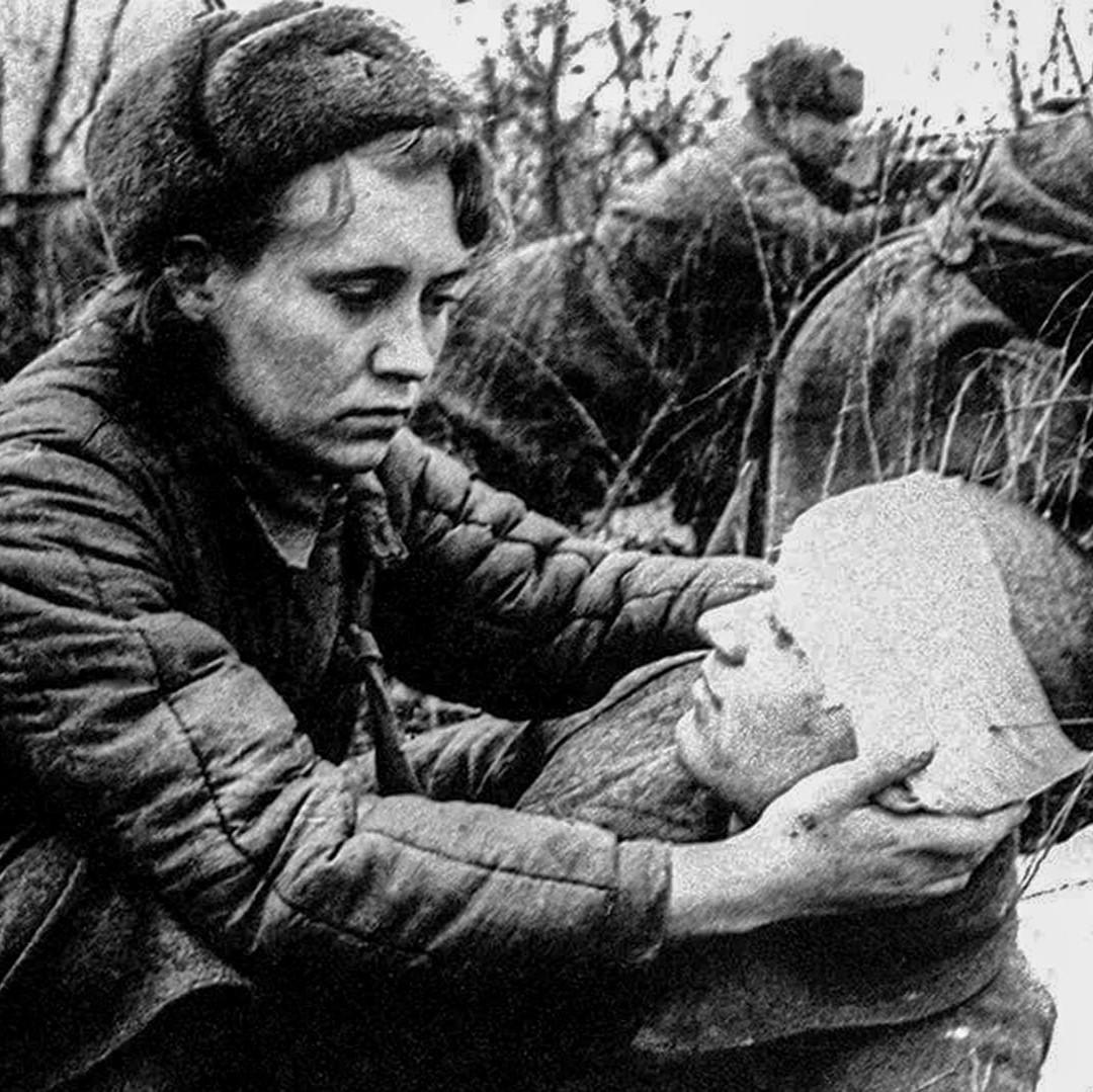 A woman in the WWII russian army tends to a wounded solider